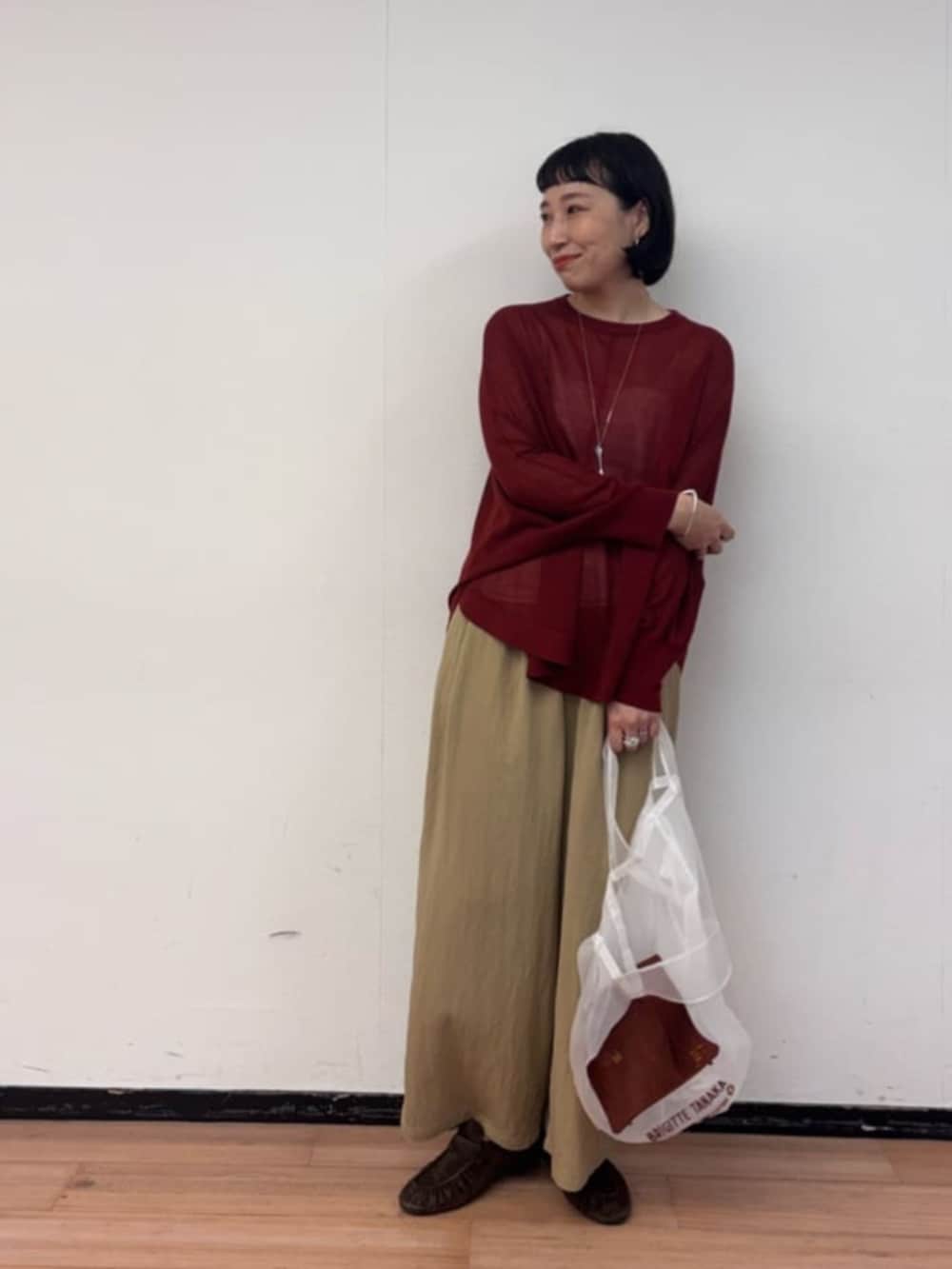 レッド系のニット/セーター、イエロー系のその他パンツ、ブラウン系のその他シューズを着用したレディースの夏コーディネートの3枚目の写真