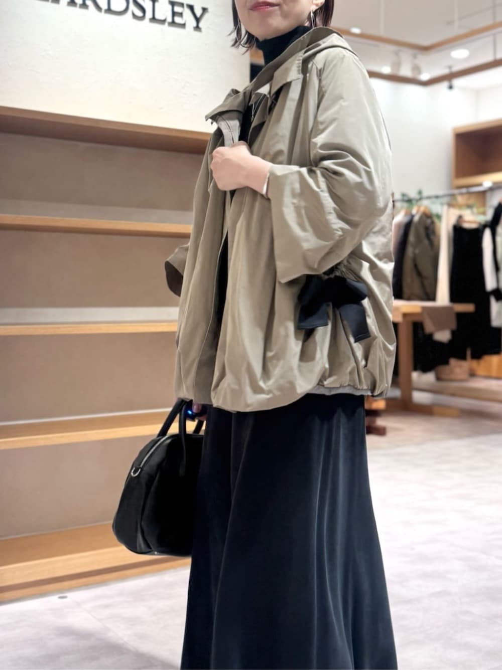 ブラック系のスカート、ブラウン系のブルゾンを着用したレディースの冬コーディネートの7枚目の写真