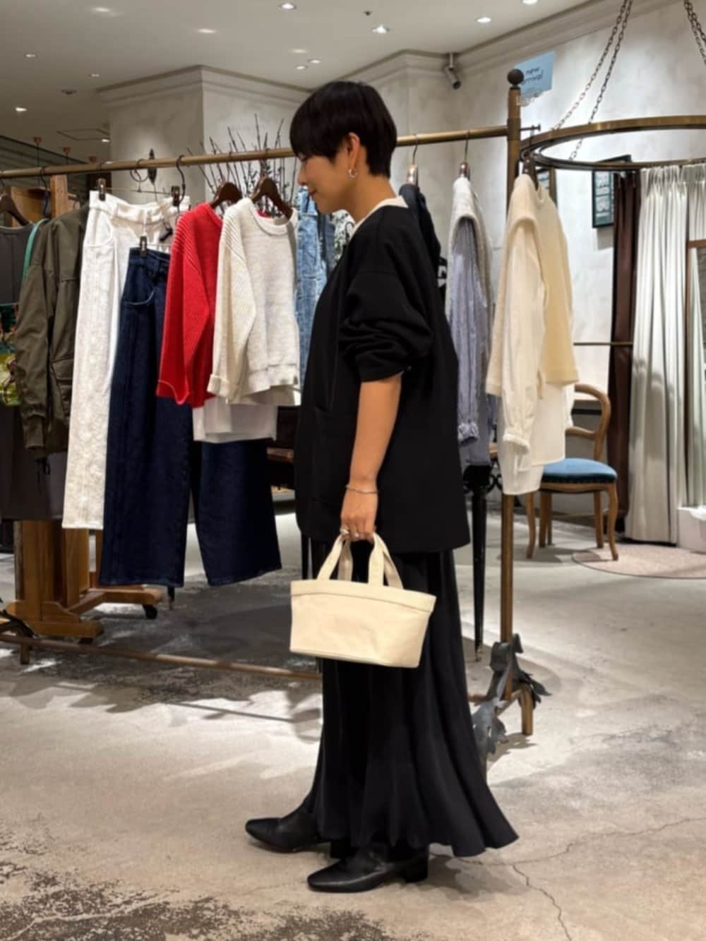 ブラック系のスカート、ベージュ系のトートバッグ、ホワイト系のシャツ/ブラウスを着用したレディースの冬コーディネートの2枚目の写真