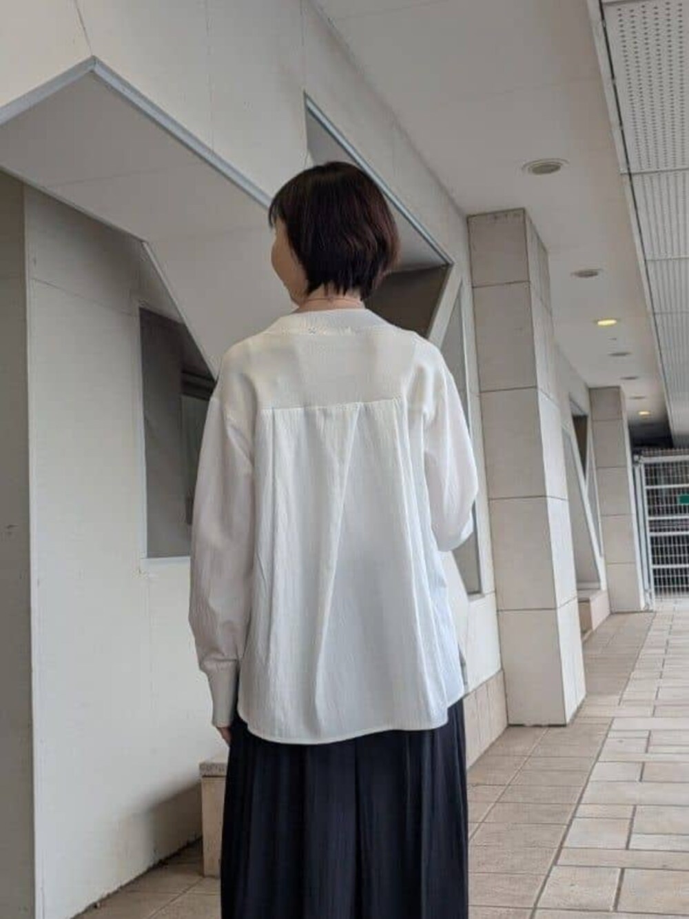 グリーン系のハンドバッグ、ブラック系のその他パンツ、ブラウン系のブルゾンを着用したレディースの冬コーディネートの8枚目の写真