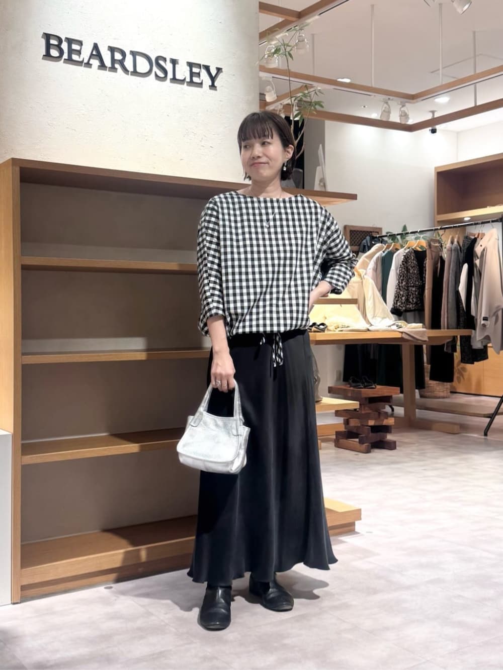 ブラック系のスカート、シルバー系のトートバッグ、ブラック系のシャツ/ブラウスを着用したレディースの冬コーディネートの2枚目の写真