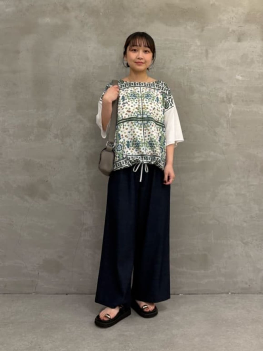 ブラック系のサンダル、ホワイト系のTシャツ/カットソーを着用したレディースの春コーディネートの2枚目の写真