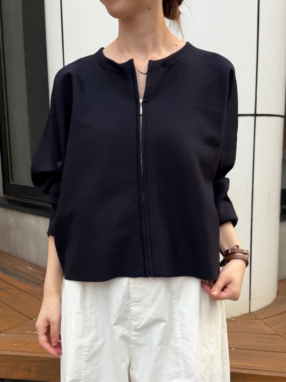 ベージュ系のスカート、ブルー系のカーディガン/ボレロ、シルバー系のトートバッグを着用したレディースの夏コーディネートの4枚目の写真