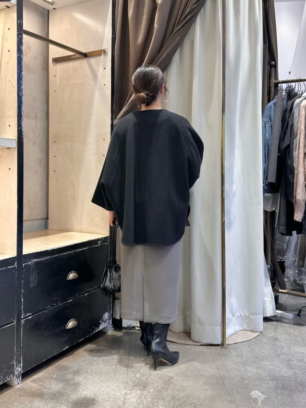 ブラック系のその他アウター、ブラウン系のスカート、ブラック系のブーツを着用したレディースの冬コーディネートの3枚目の写真