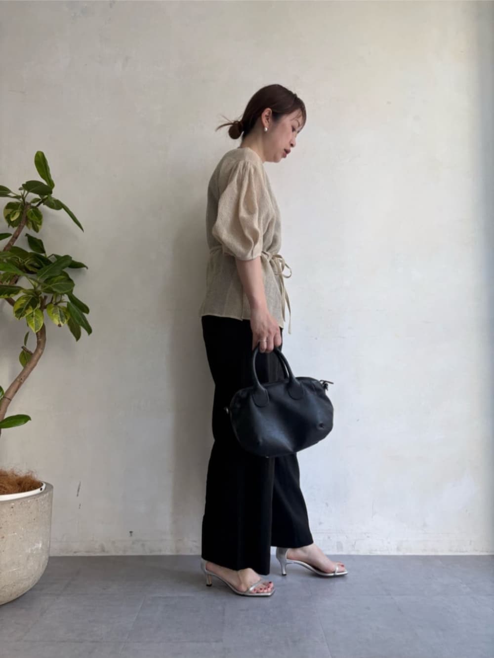ブラック系のボストンバッグ、ブラック系のその他パンツ、ベージュ系のシャツ/ブラウスを着用したレディースの春コーディネートの2枚目の写真