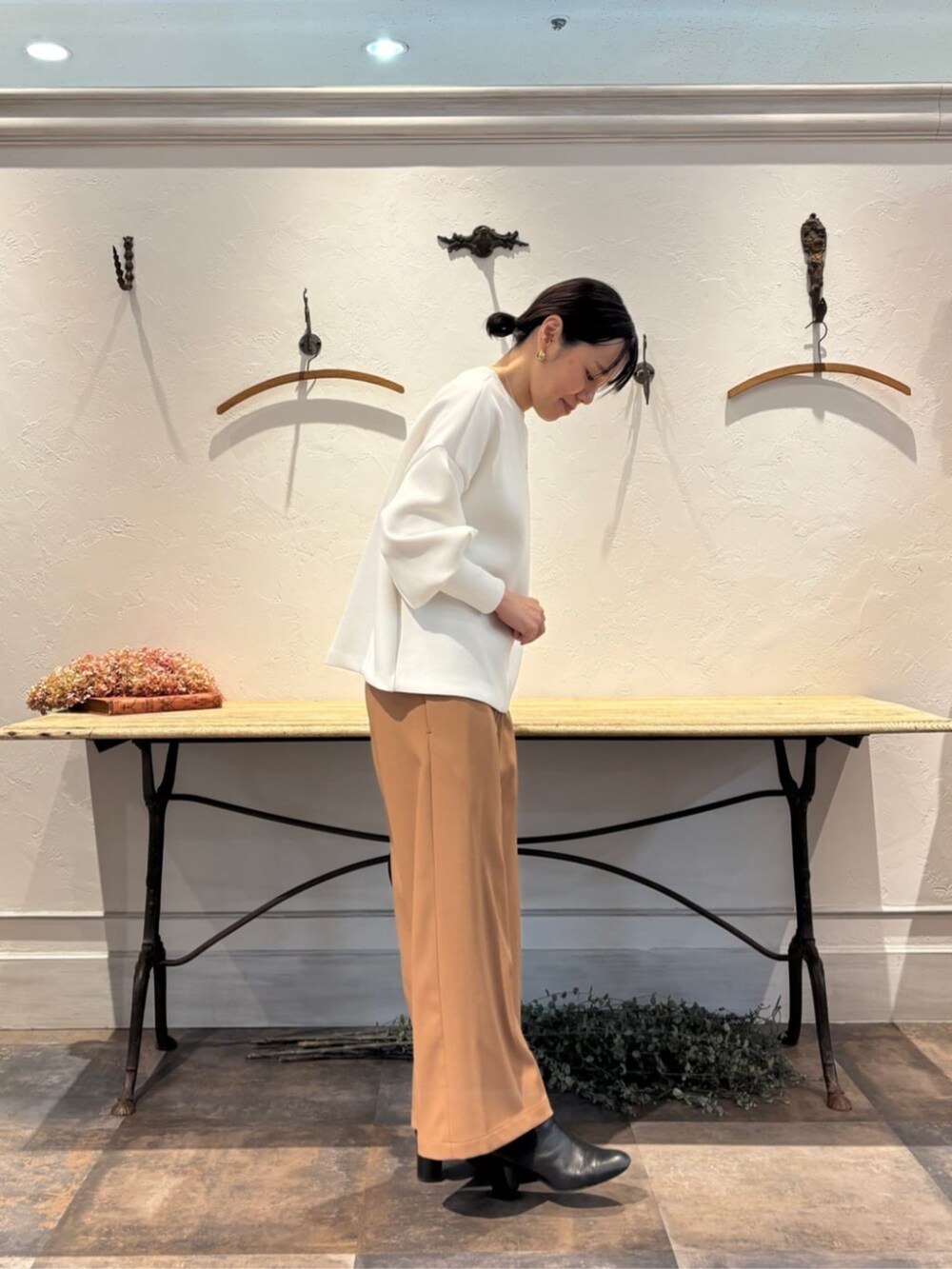 イエロー系のその他パンツ、ブラック系のトートバッグ、ホワイト系のTシャツ/カットソーを着用したレディースの冬コーディネートの2枚目の写真