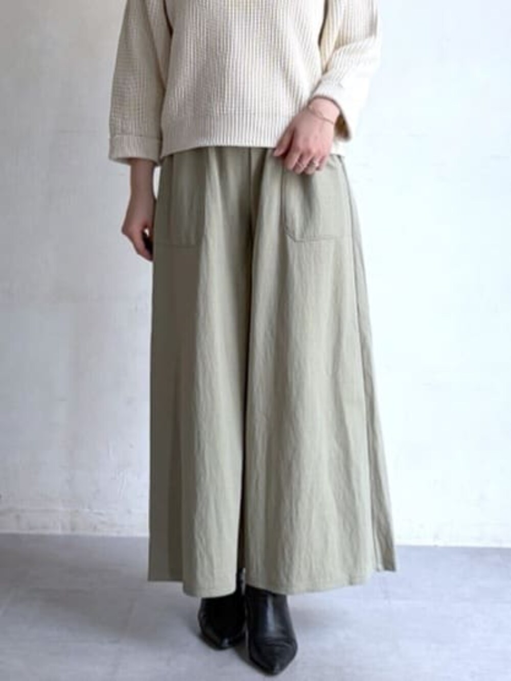 ホワイト系のニット/セーター、グリーン系のその他パンツ、ブラック系のトートバッグを着用したレディースの冬コーディネートの6枚目の写真