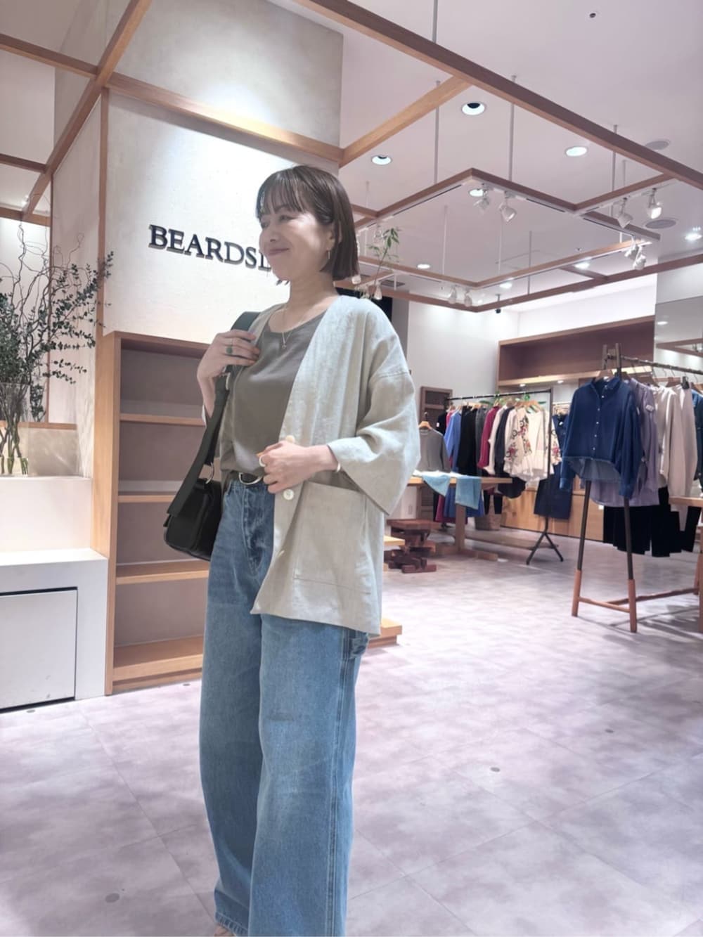 ブラック系のショルダーバッグ、ブルー系のその他パンツ、ブラウン系のキャミソールを着用したレディースの春コーディネートの3枚目の写真