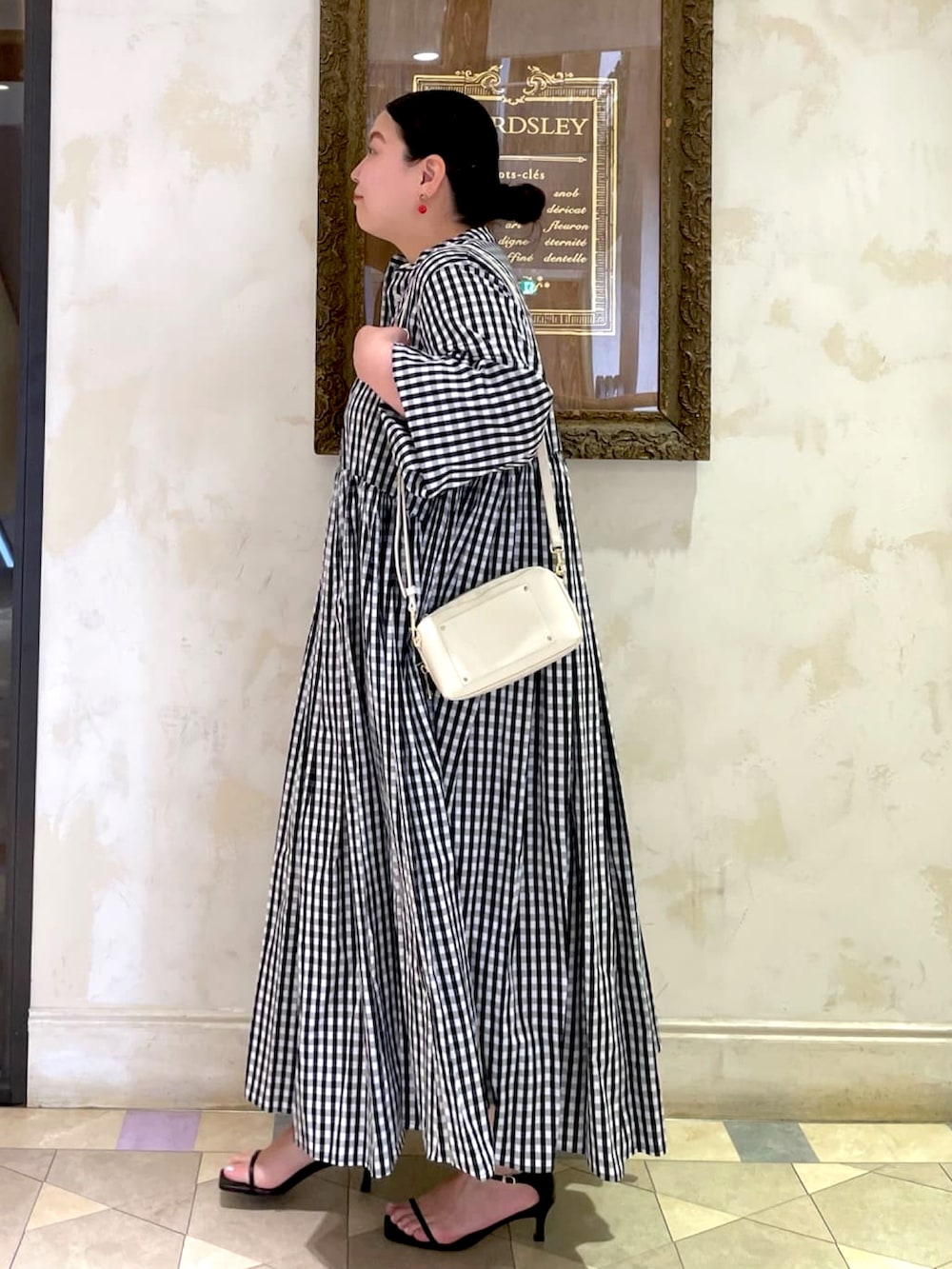 ブラック系のワンピース、ホワイト系のショルダーバッグを着用したレディースの夏コーディネートの2枚目の写真