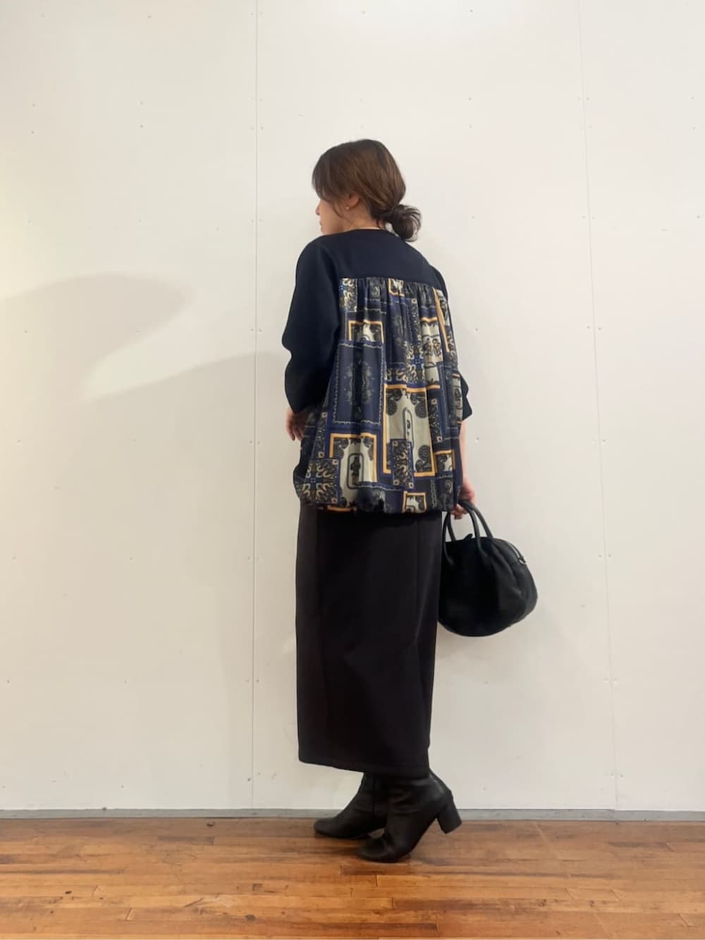 グレー系のスカート、ブラック系のトートバッグ、ブルー系のTシャツ/カットソーを着用したレディースの夏コーディネートの5枚目の写真