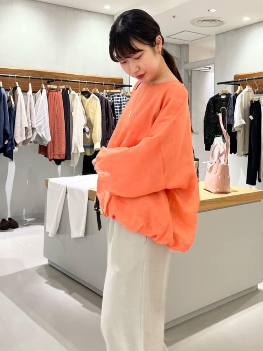 グレー系のその他パンツ、オレンジ系のシャツ/ブラウスを着用したレディースの春コーディネートの5枚目の写真