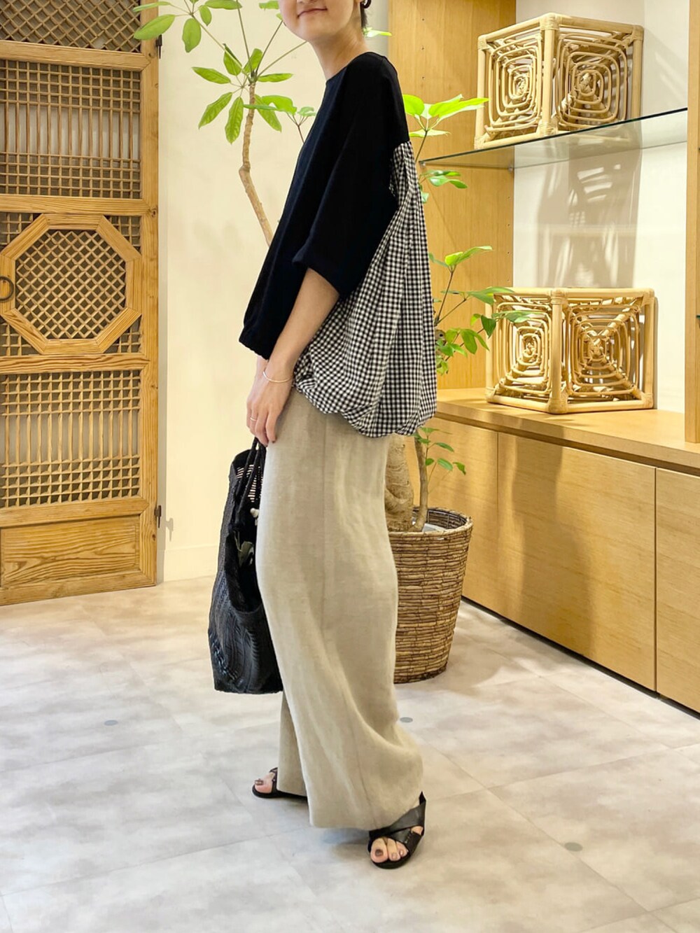 ブラック系のTシャツ/カットソー、ベージュ系のその他パンツ、ブラック系のサンダルを着用したレディースの夏コーディネートの2枚目の写真