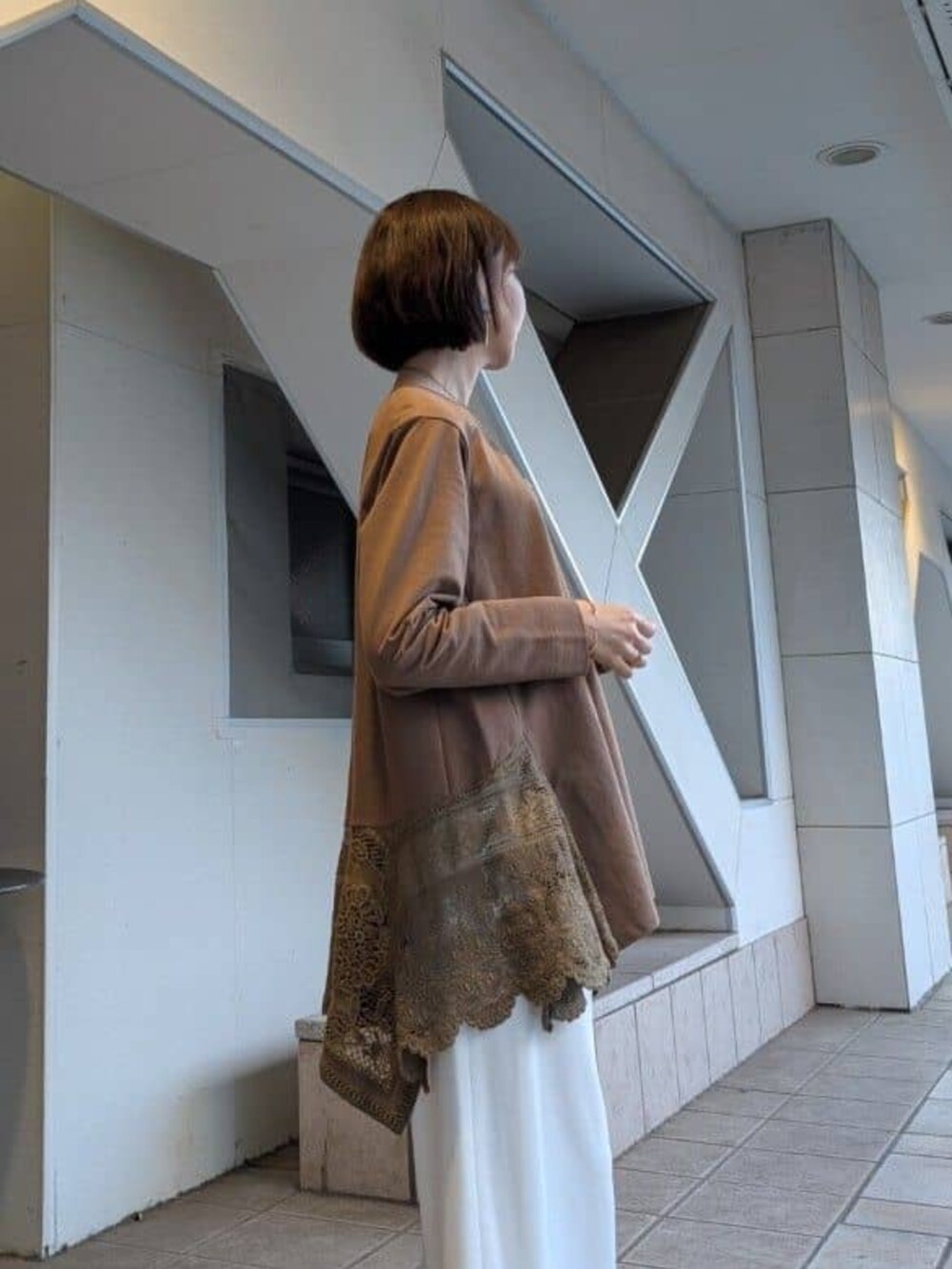 ホワイト系のその他パンツ、ブラウン系のTシャツ/カットソーを着用したレディースの冬コーディネートの3枚目の写真