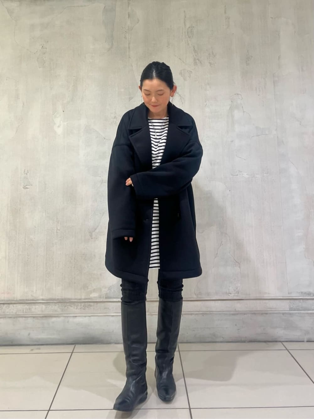 ブルー系のTシャツ/カットソー、ブラック系のデニムパンツ、ブラック系のピーコートを着用したレディースの冬コーディネートの8枚目の写真