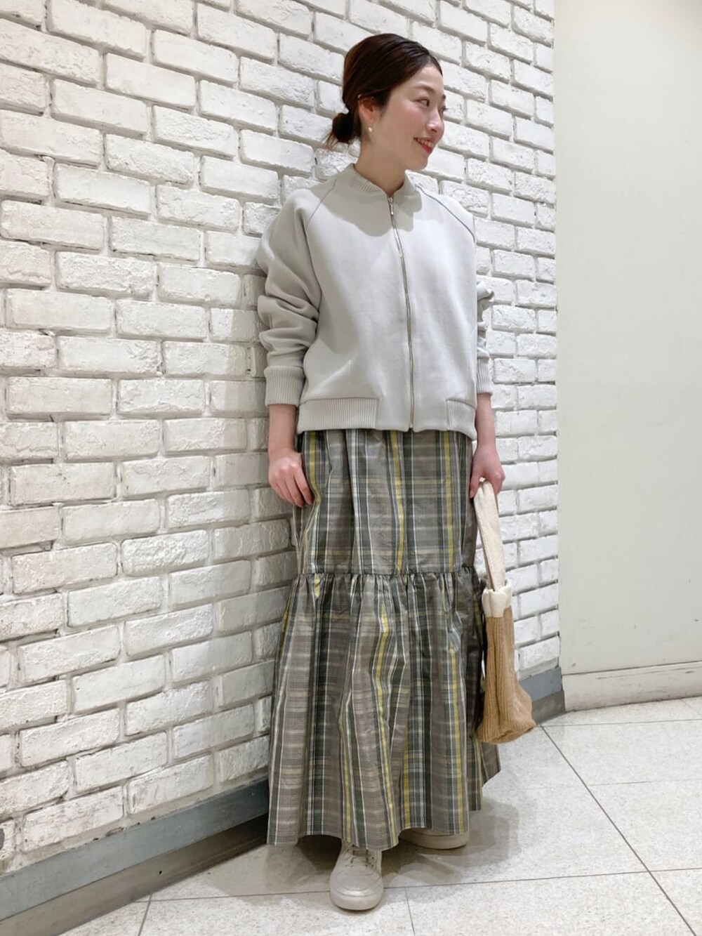 グレー系のブルゾン、グレー系のスカートを着用したレディースの冬コーディネートの2枚目の写真