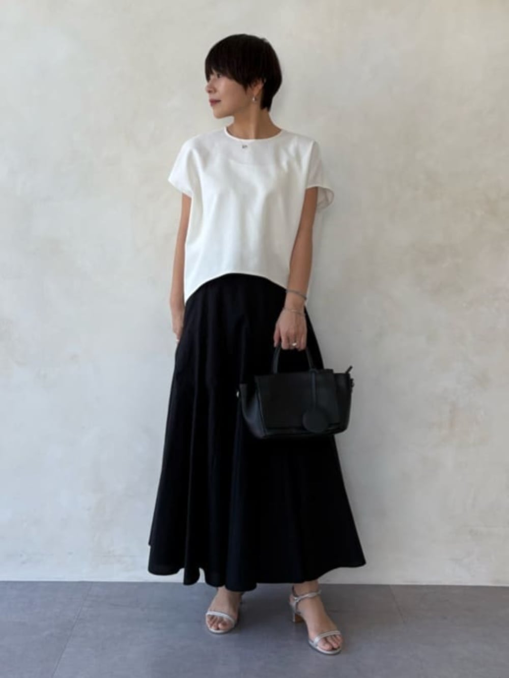 ベージュ系のテーラードジャケット、ホワイト系のシャツ/ブラウス、ブラック系のスカートを着用したレディースの春コーディネートの9枚目の写真