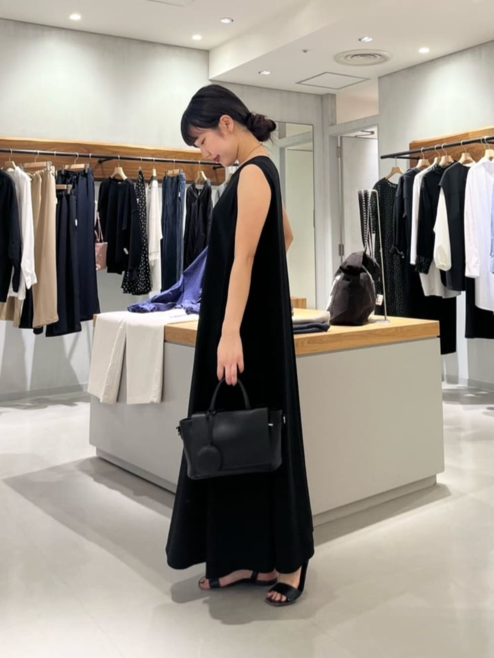 ブラック系のハンドバッグ、ブラック系のワンピースを着用したレディースの春コーディネートの6枚目の写真