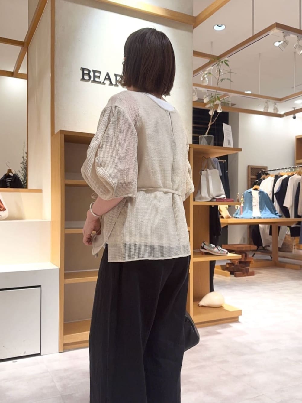 ベージュ系のシャツ/ブラウス、ブラック系のその他パンツを着用したレディースの春コーディネートの7枚目の写真