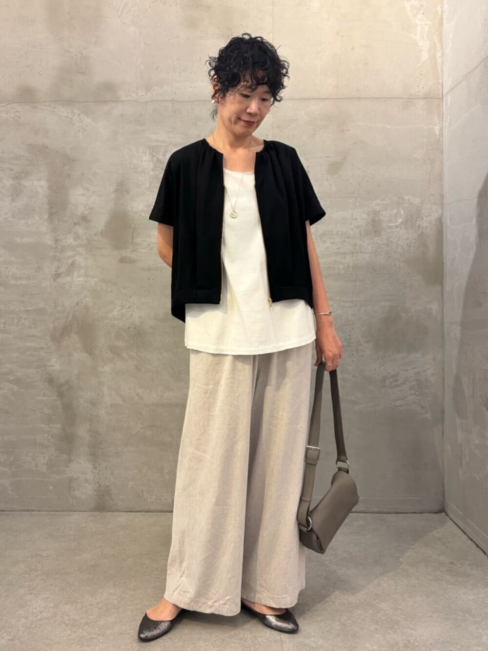 ベージュ系のその他パンツ、ホワイト系のシャツ/ブラウス、ブラック系のベストを着用したレディースの春コーディネートの3枚目の写真
