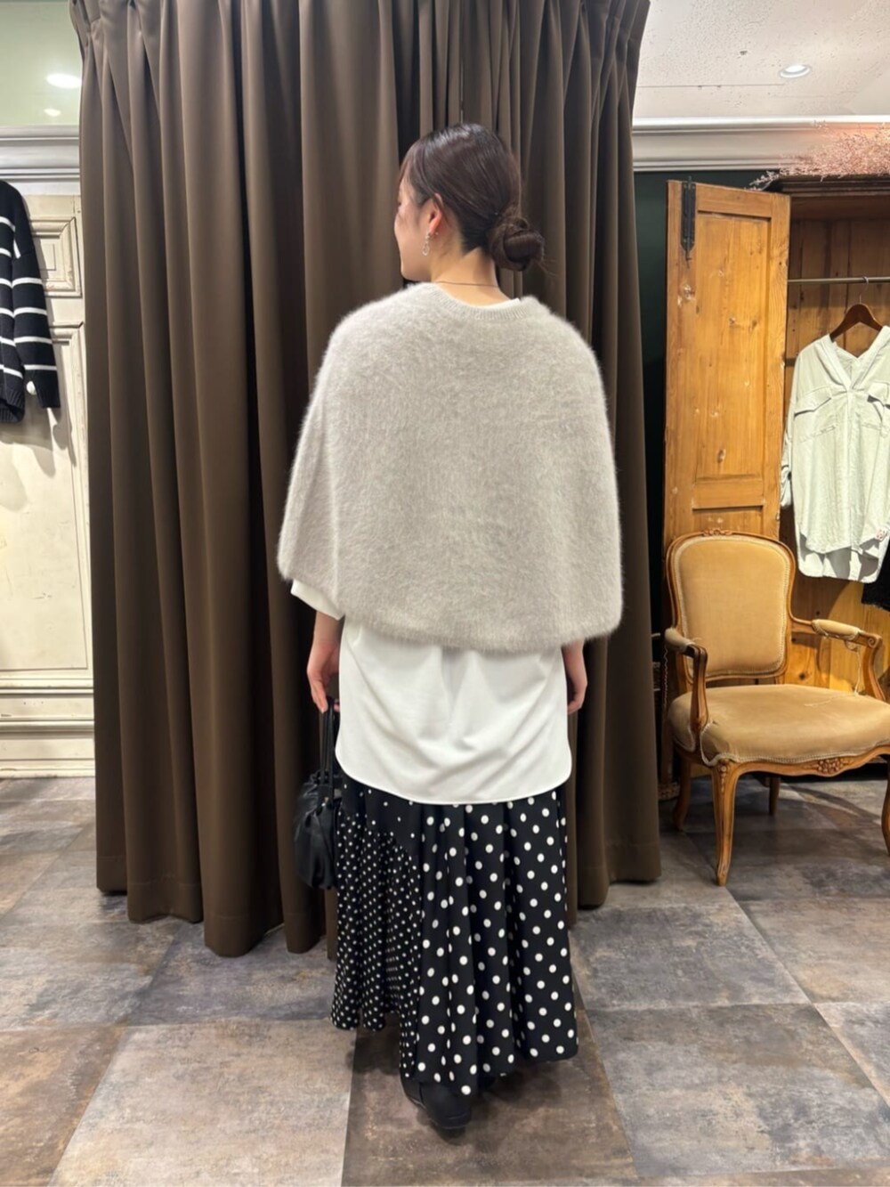 グレー系のニット/セーター、ホワイト系のシャツ/ブラウスを着用したレディースの冬コーディネートの2枚目の写真