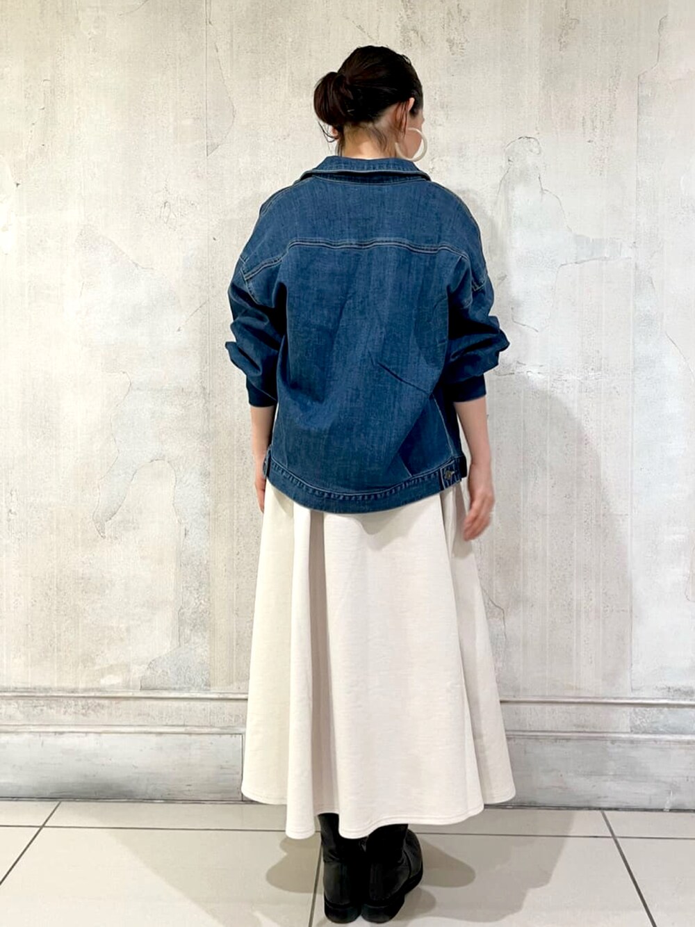 ブルー系のデニムジャケット、ホワイト系のワンピース、ブラック系のトートバッグを着用したレディースの春コーディネートの3枚目の写真