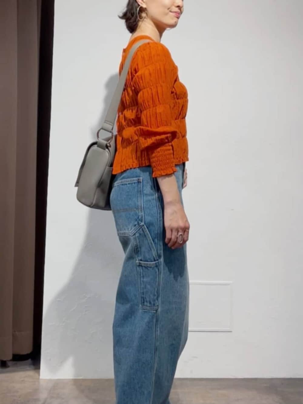 オレンジ系のシャツ/ブラウス、ブルー系のその他パンツ、ホワイト系のサンダルを着用したレディースの春コーディネートの3枚目の写真