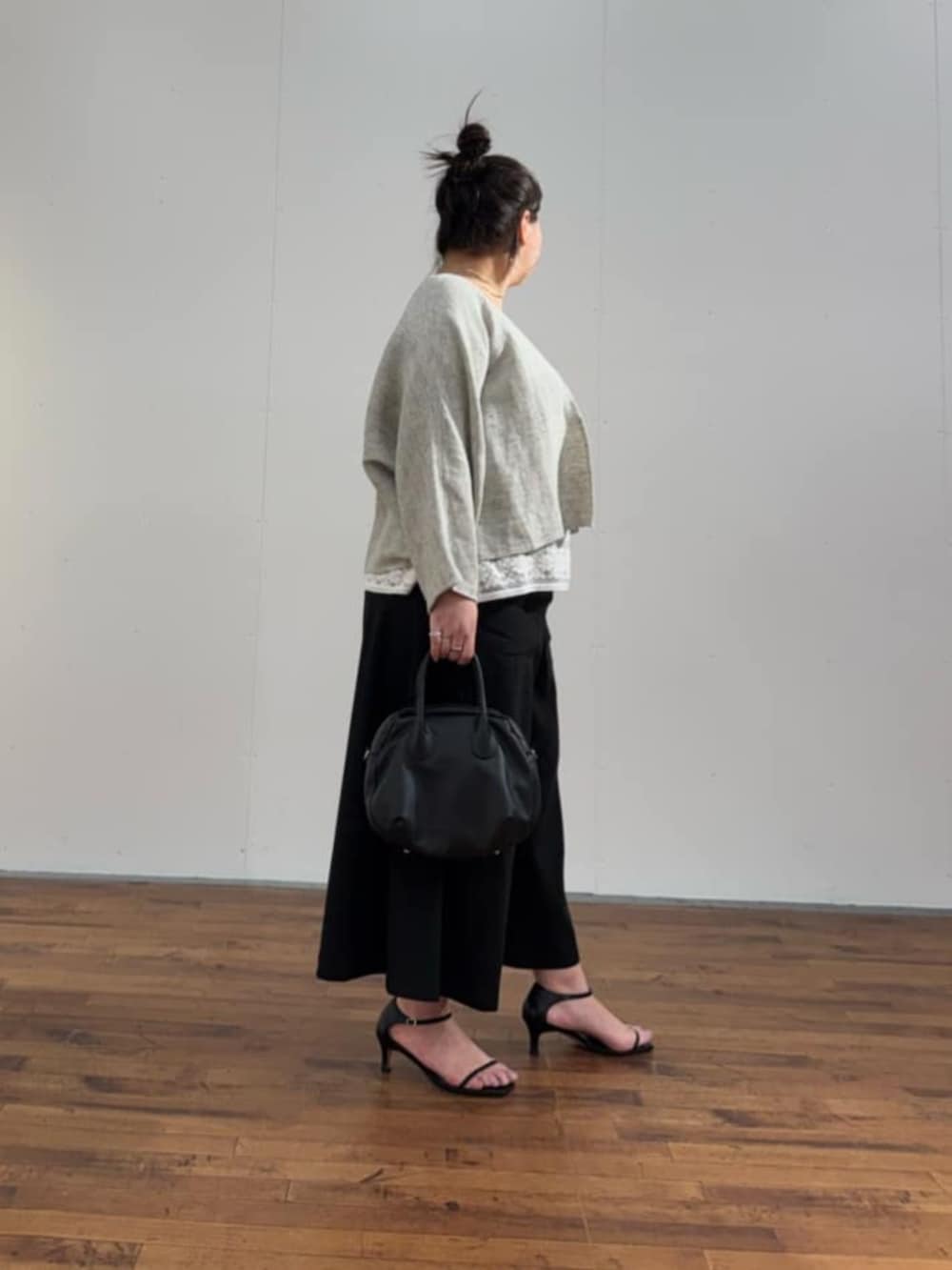 ブラック系のボストンバッグ、ホワイト系のシャツ/ブラウス、グレー系のカーディガン/ボレロを着用したレディースの春コーディネートの4枚目の写真