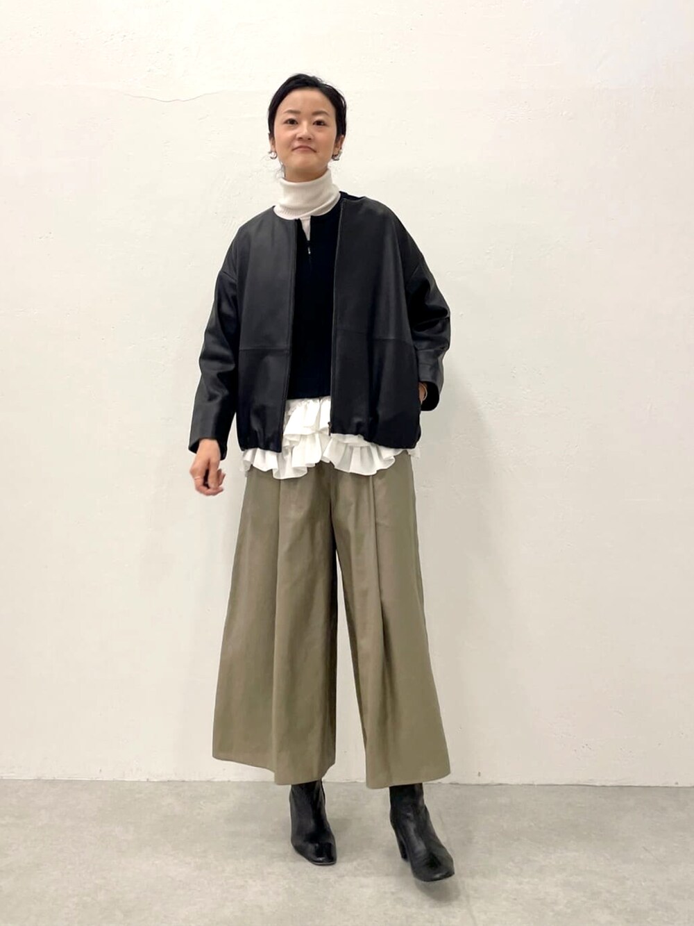 ブラック系のブルゾン、グリーン系のその他パンツ、ホワイト系のニット/セーターを着用したレディースの冬コーディネートの4枚目の写真