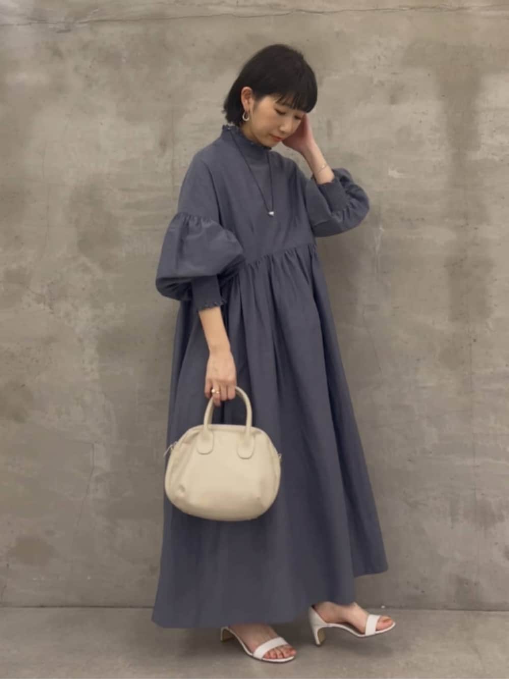 グレー系のボストンバッグ、グレー系のワンピースを着用したレディースの冬コーディネートの3枚目の写真