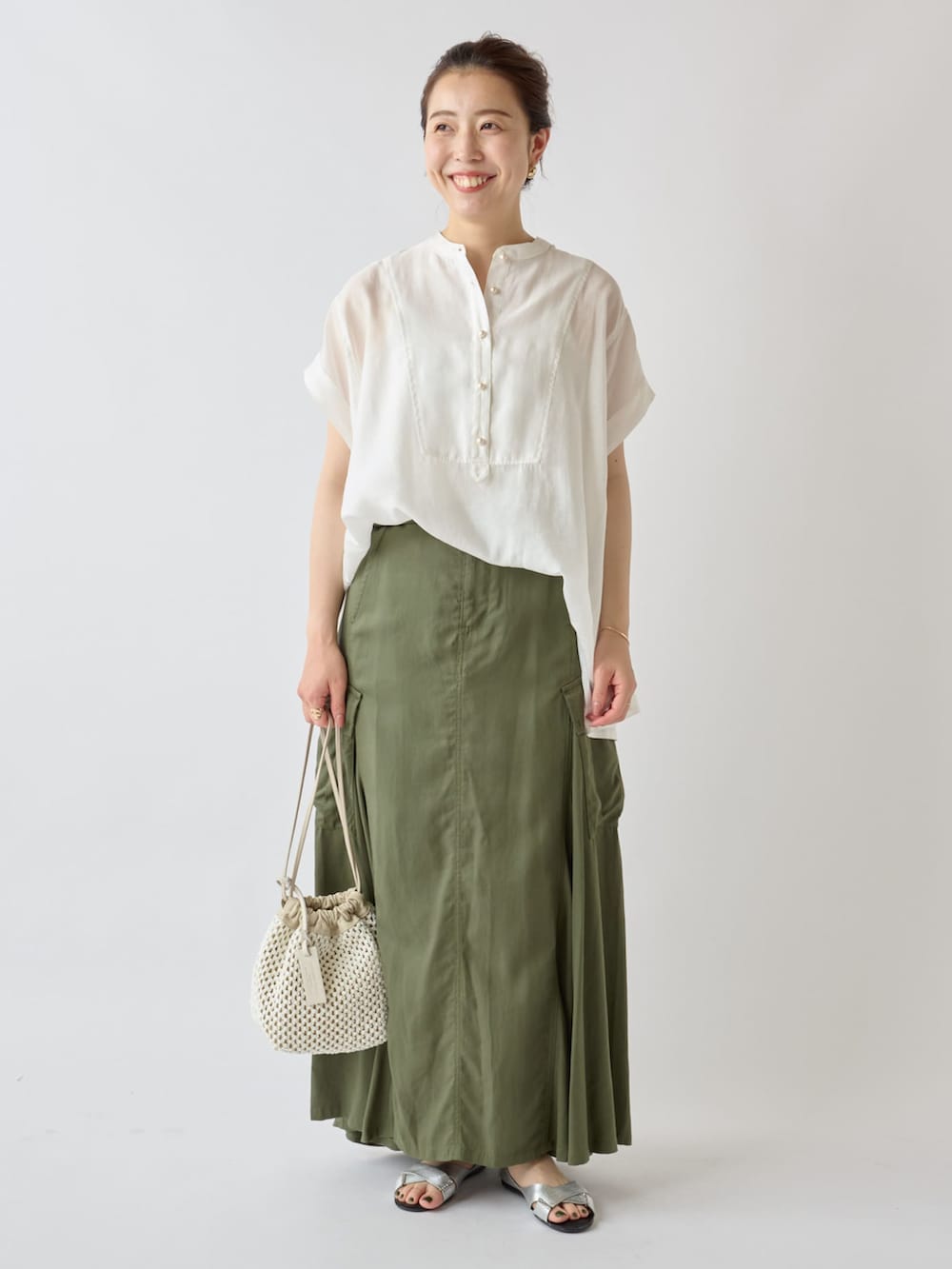 ベージュ系のノーカラージャケット、ホワイト系のシャツ/ブラウス、グリーン系のスカートを着用したレディースの夏コーディネートの3枚目の写真