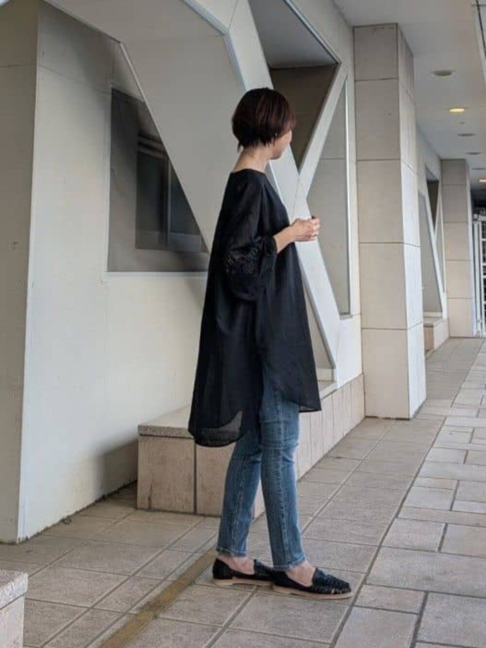 ブラック系のシャツ/ブラウスを着用したレディースの春コーディネートの3枚目の写真