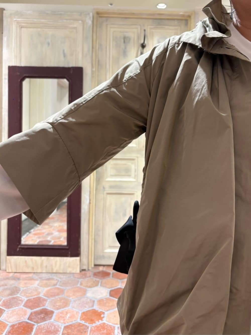 グリーン系のハンドバッグ、ブラック系のスカート、ブラウン系のブルゾンを着用したレディースの冬コーディネートの4枚目の写真