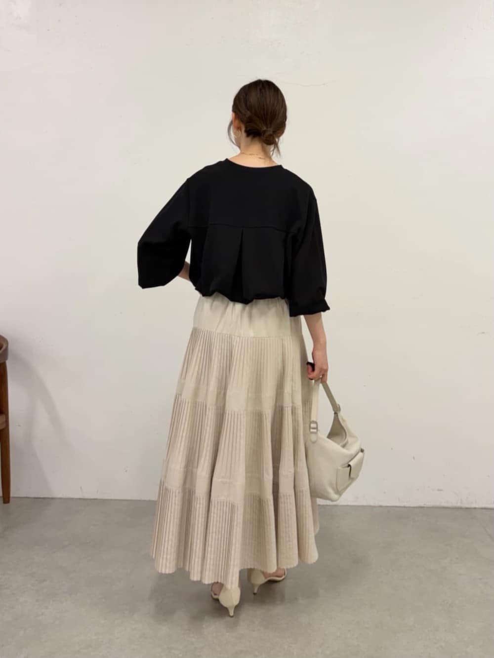 ホワイト系のスカート、ブラック系のシャツ/ブラウスを着用したレディースの春コーディネートの3枚目の写真