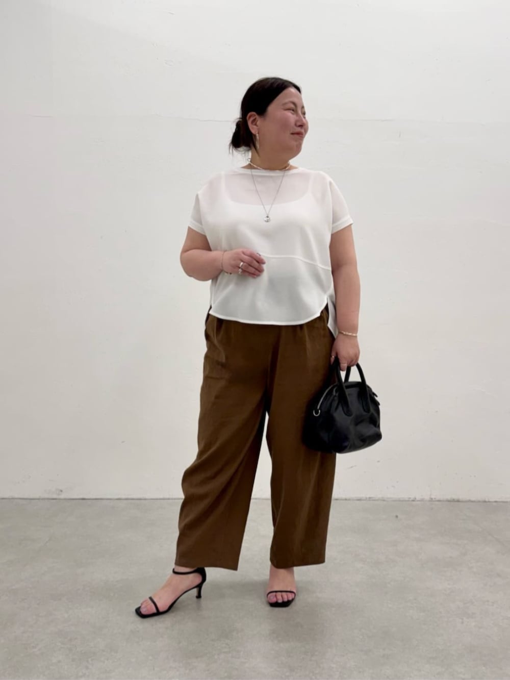 ブラック系のボストンバッグ、ホワイト系のシャツ/ブラウス、ブラウン系のその他パンツを着用したレディースの春コーディネートの2枚目の写真