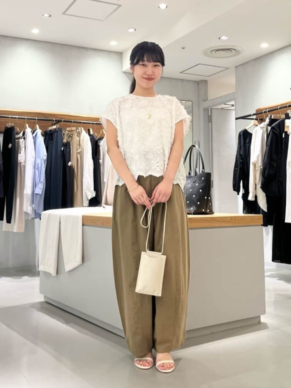 ホワイト系のショルダーバッグ、イエロー系のその他パンツ、ホワイト系のシャツ/ブラウスを着用したレディースの夏コーディネートの5枚目の写真