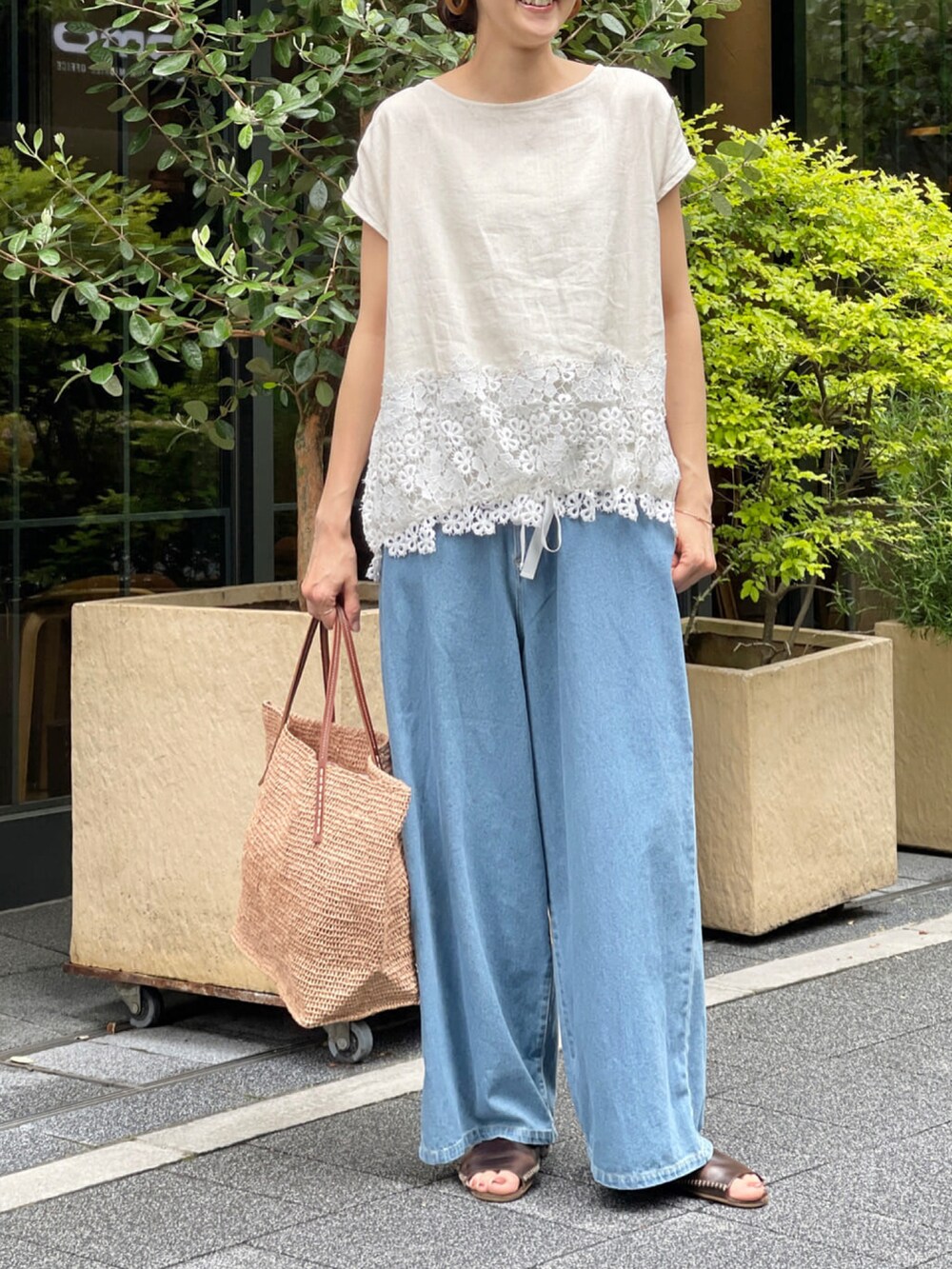 ベージュ系のシャツ/ブラウス、ブルー系のデニムパンツ、ベージュ系のかごバッグを着用したレディースの春コーディネートの4枚目の写真