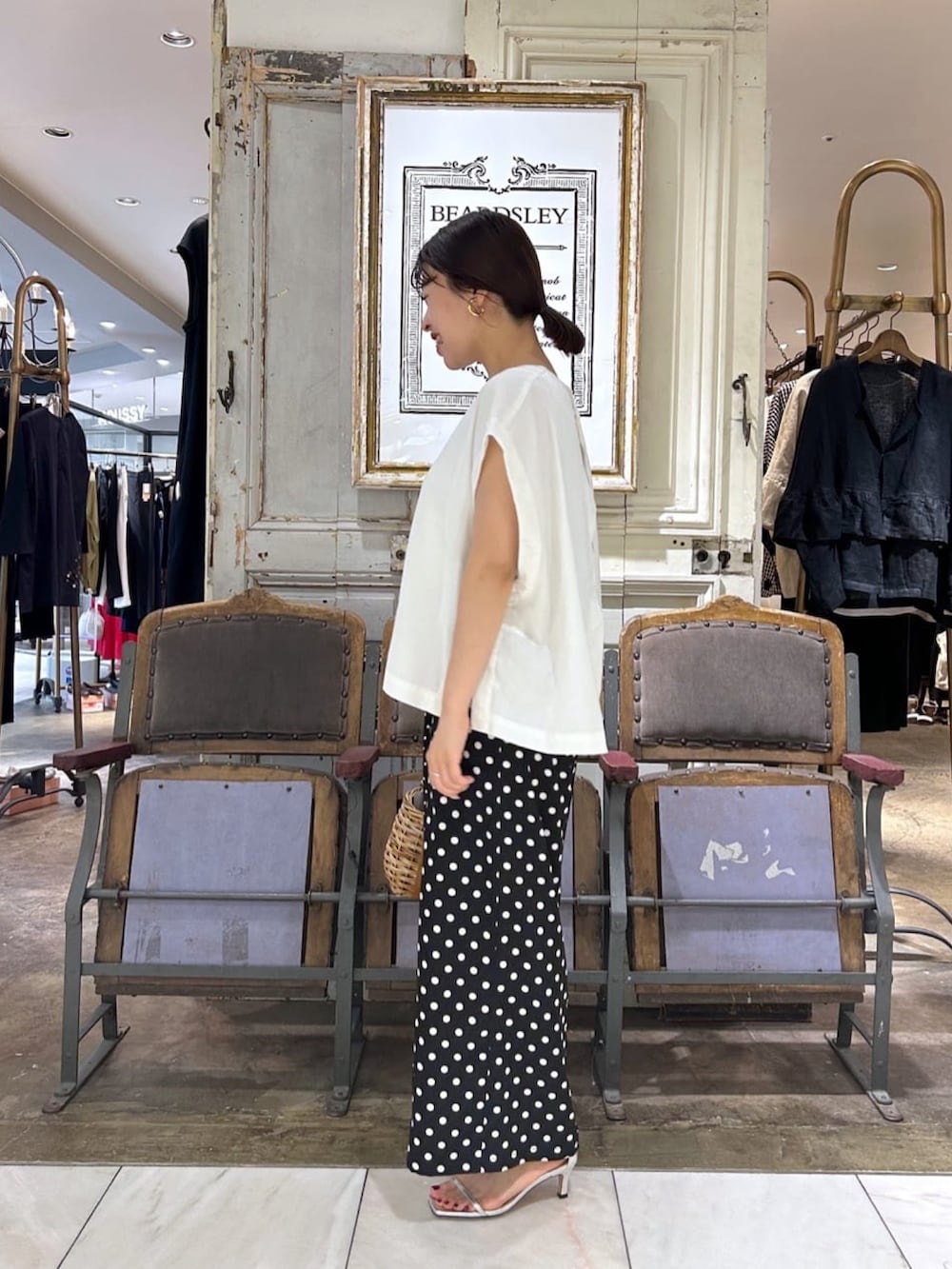 ホワイト系のベスト、ブラック系のその他パンツを着用したレディースの夏コーディネートの2枚目の写真