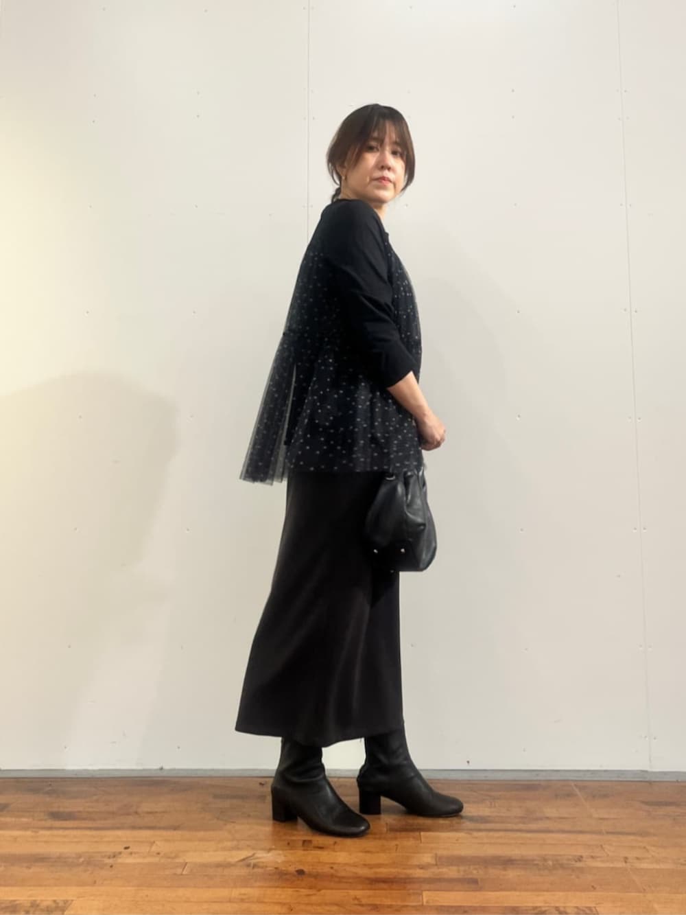 ブラック系のボストンバッグ、グレー系のスカート、ブラック系のTシャツ/カットソーを着用したレディースの夏コーディネートの3枚目の写真