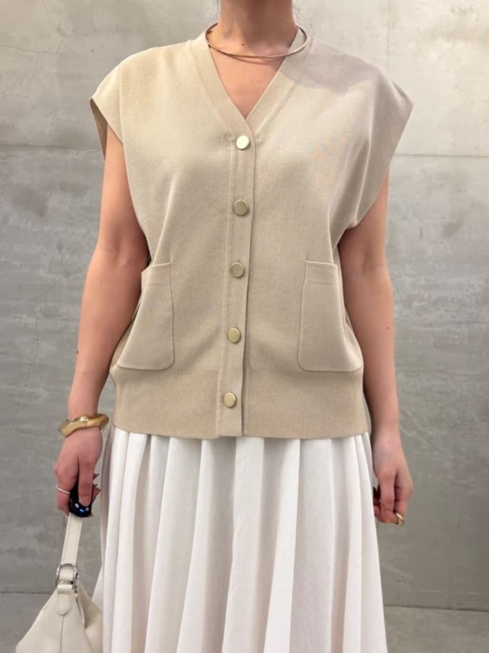 ホワイト系のスカート、ベージュ系のカーディガン/ボレロを着用したレディースの春コーディネートの5枚目の写真