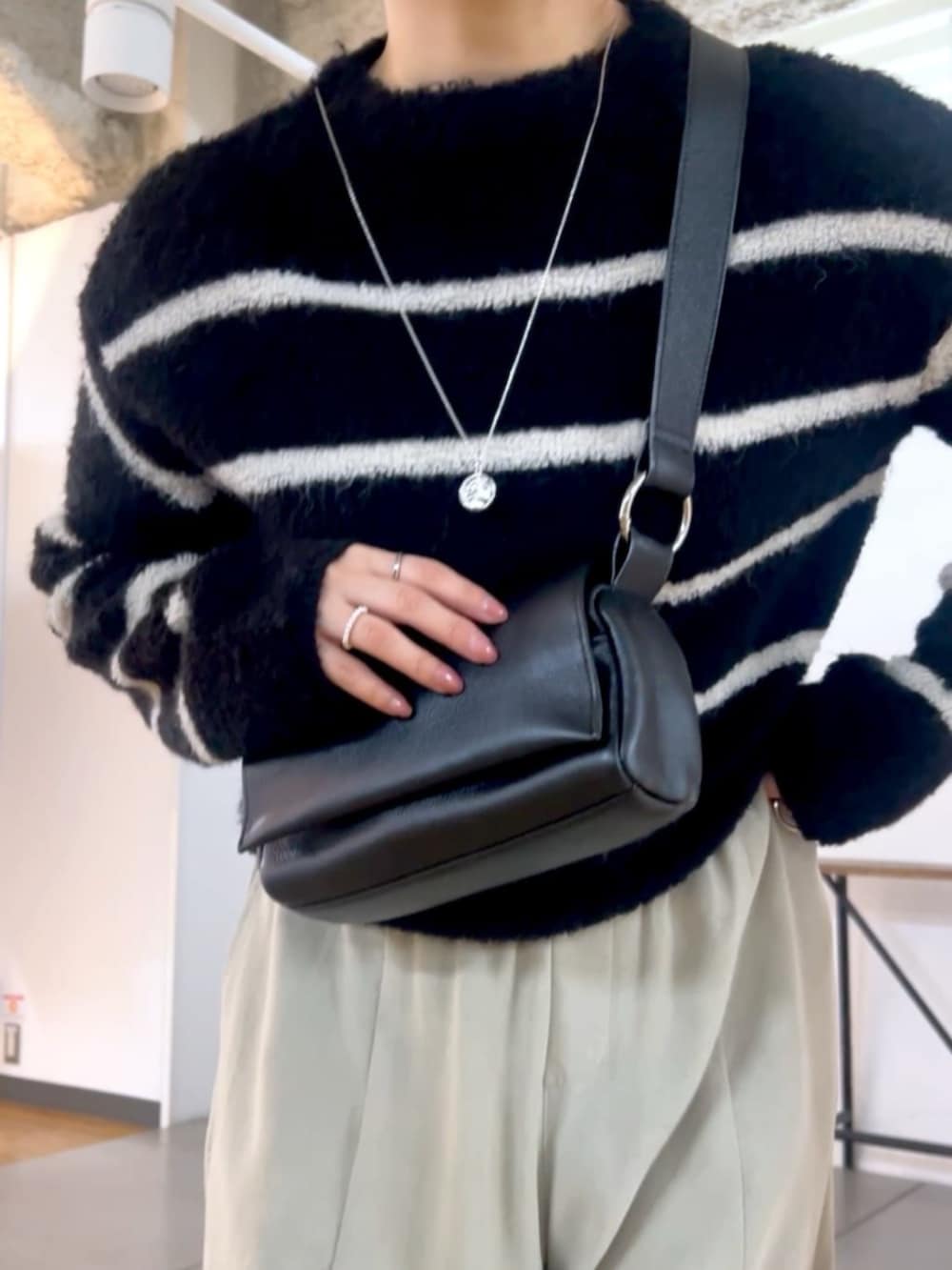ブラック系のショルダーバッグ、グレー系のその他パンツ、ブラック系のニット/セーターを着用したレディースの秋コーディネートの6枚目の写真