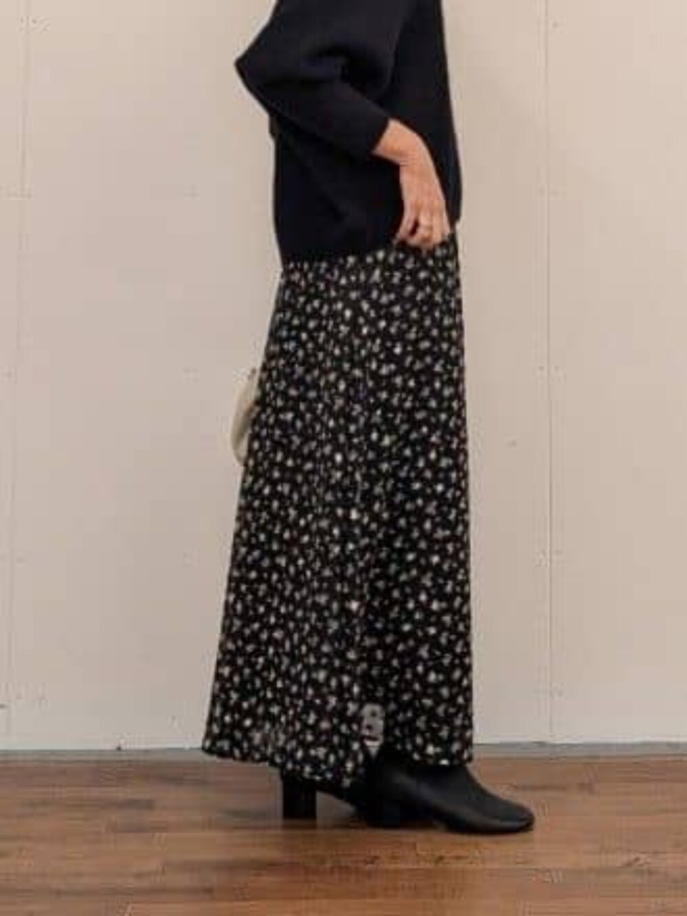 ブラック系のスカート、ブラック系のブーツ、グレー系のその他アウターを着用したレディースの秋コーディネートの7枚目の写真