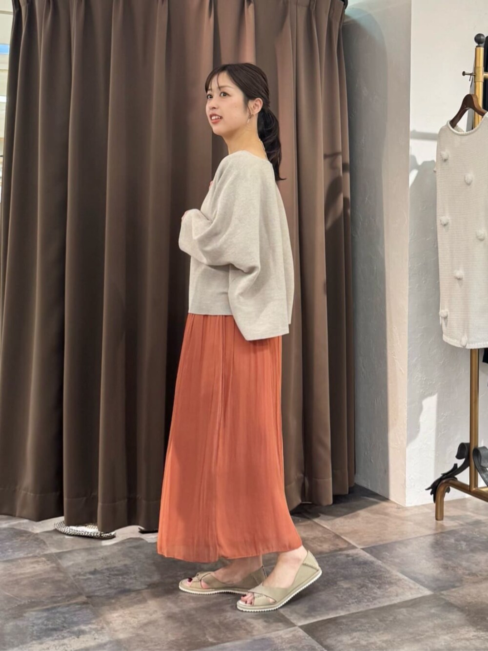 オレンジ系のその他パンツ、ベージュ系のニット/セーターを着用したレディースの春コーディネートの2枚目の写真