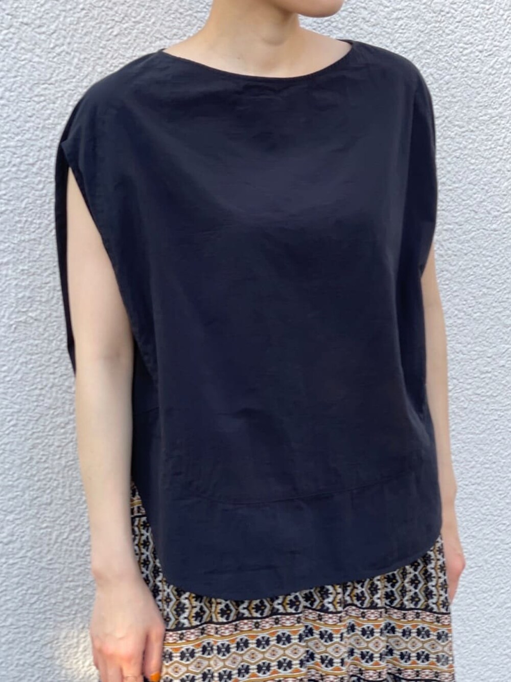 ブラック系のシャツ/ブラウス、ブラック系のスカート、シルバー系のサンダルを着用したレディースの夏コーディネートの3枚目の写真