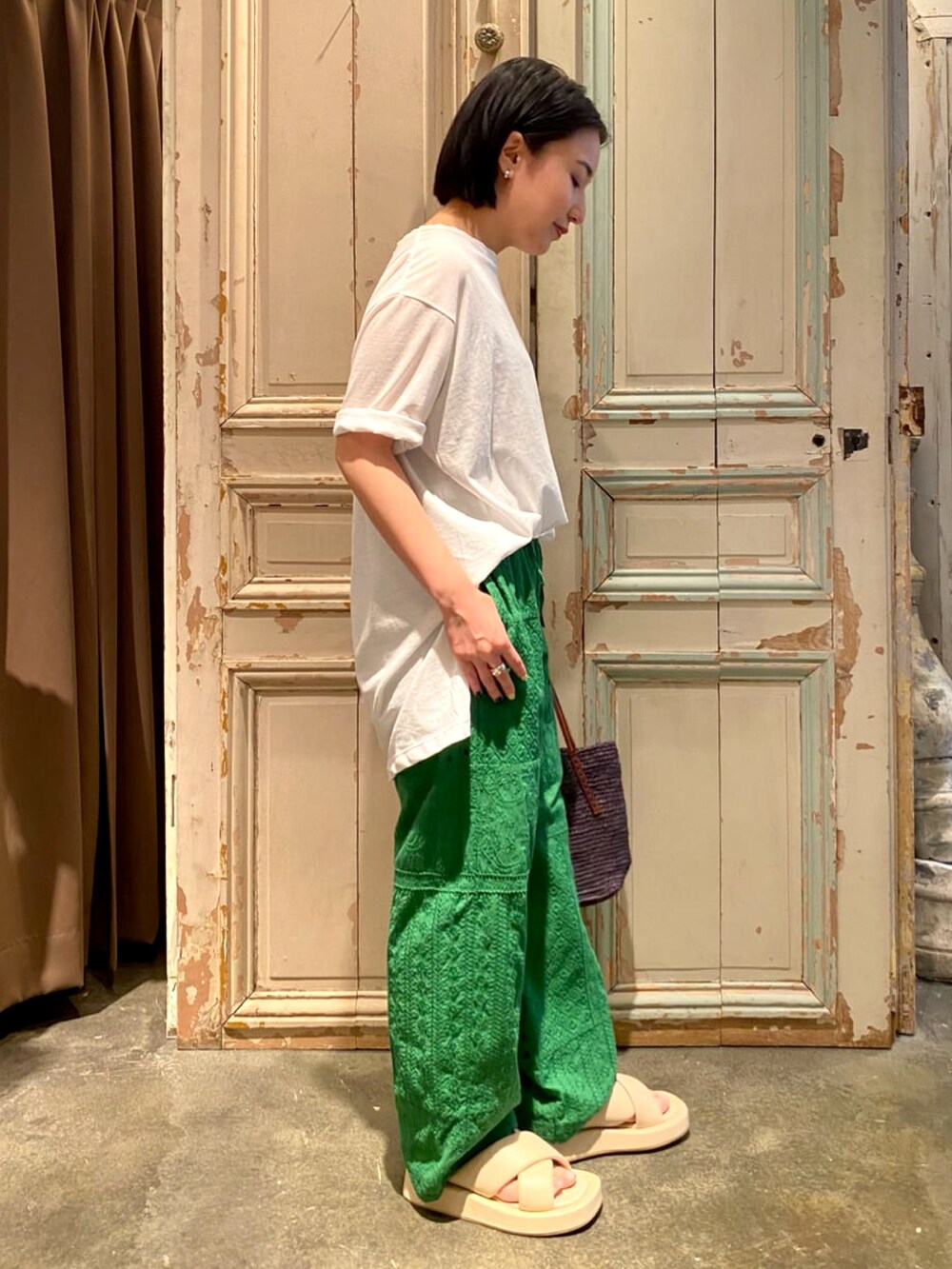 ホワイト系のTシャツ/カットソー、グリーン系のその他パンツ、ブラック系のかごバッグを着用したレディースの春コーディネートの2枚目の写真