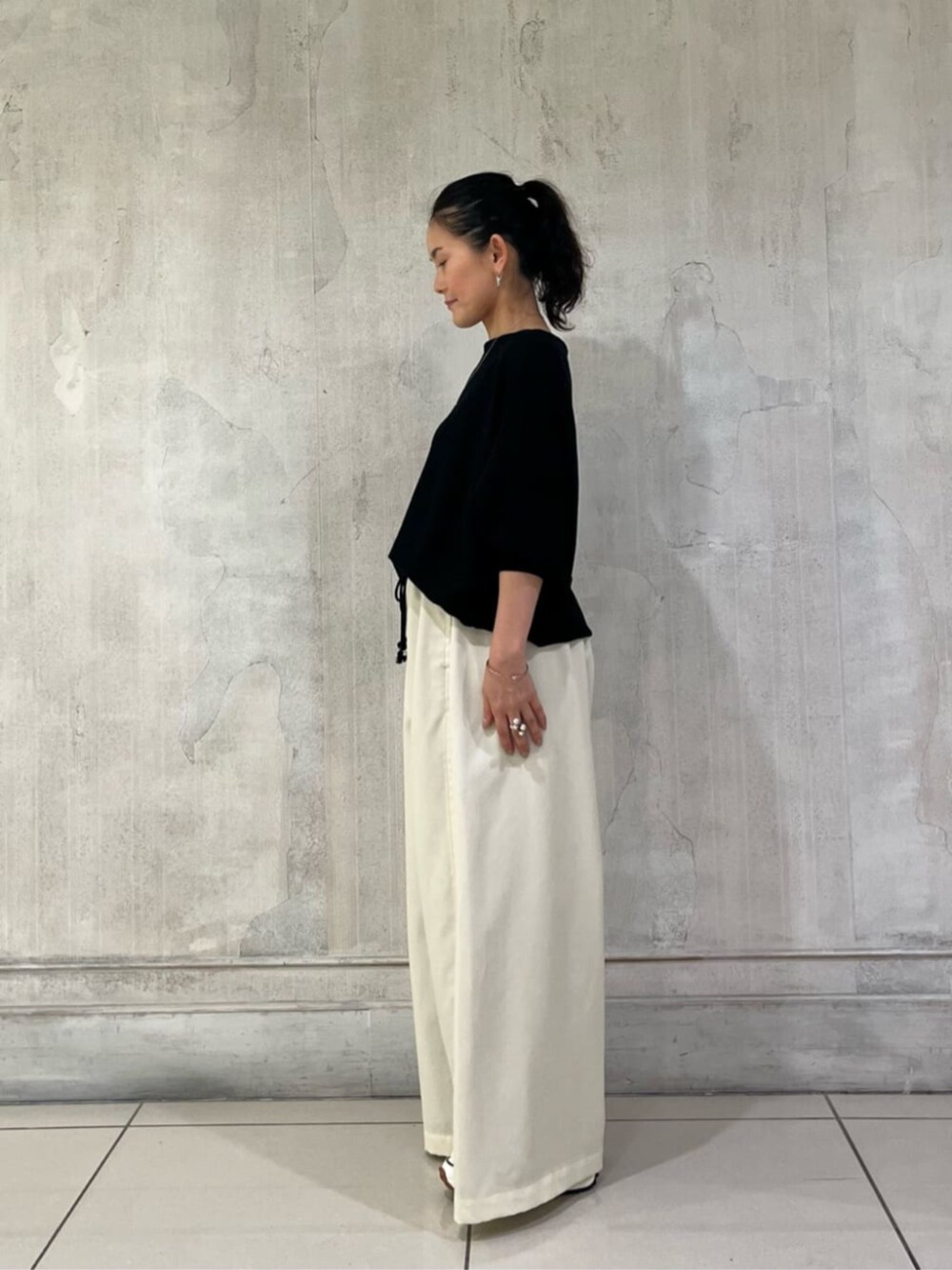 ブラック系のニット/セーター、ホワイト系のその他パンツを着用したレディースの冬コーディネートの6枚目の写真