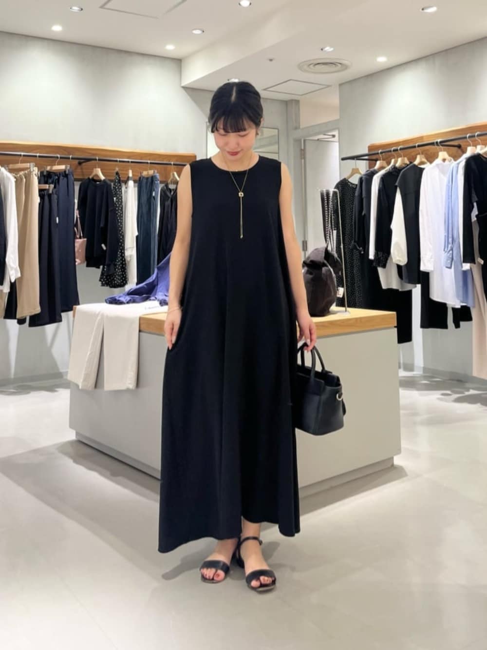 ブラック系のハンドバッグ、ブラック系のワンピースを着用したレディースの春コーディネートの8枚目の写真