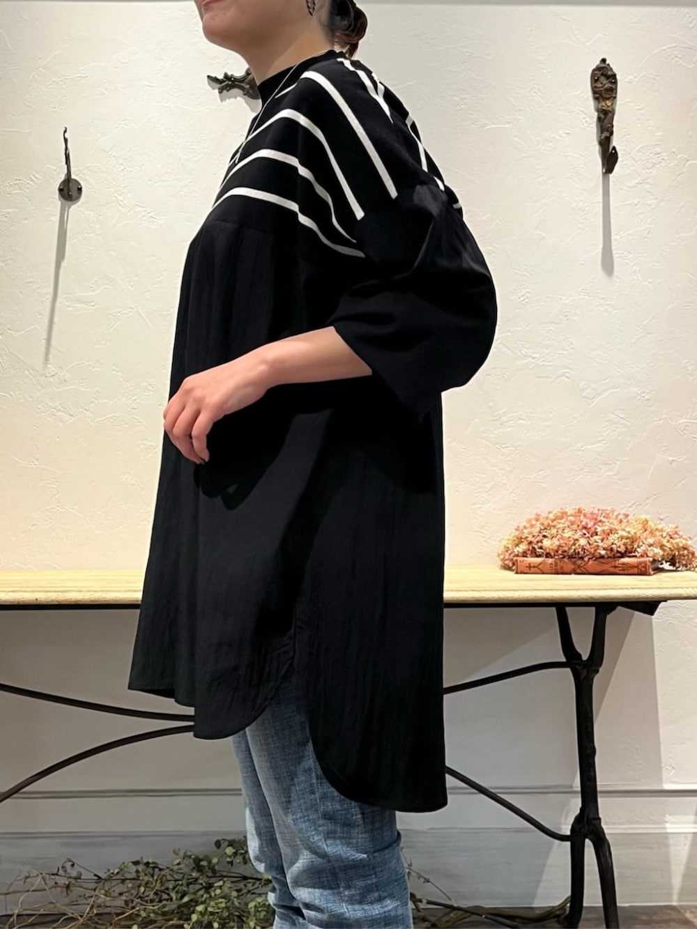 ブルー系のデニムパンツ、グレー系のハンドバッグ、ブラック系のニット/セーターを着用したレディースの冬コーディネートの4枚目の写真