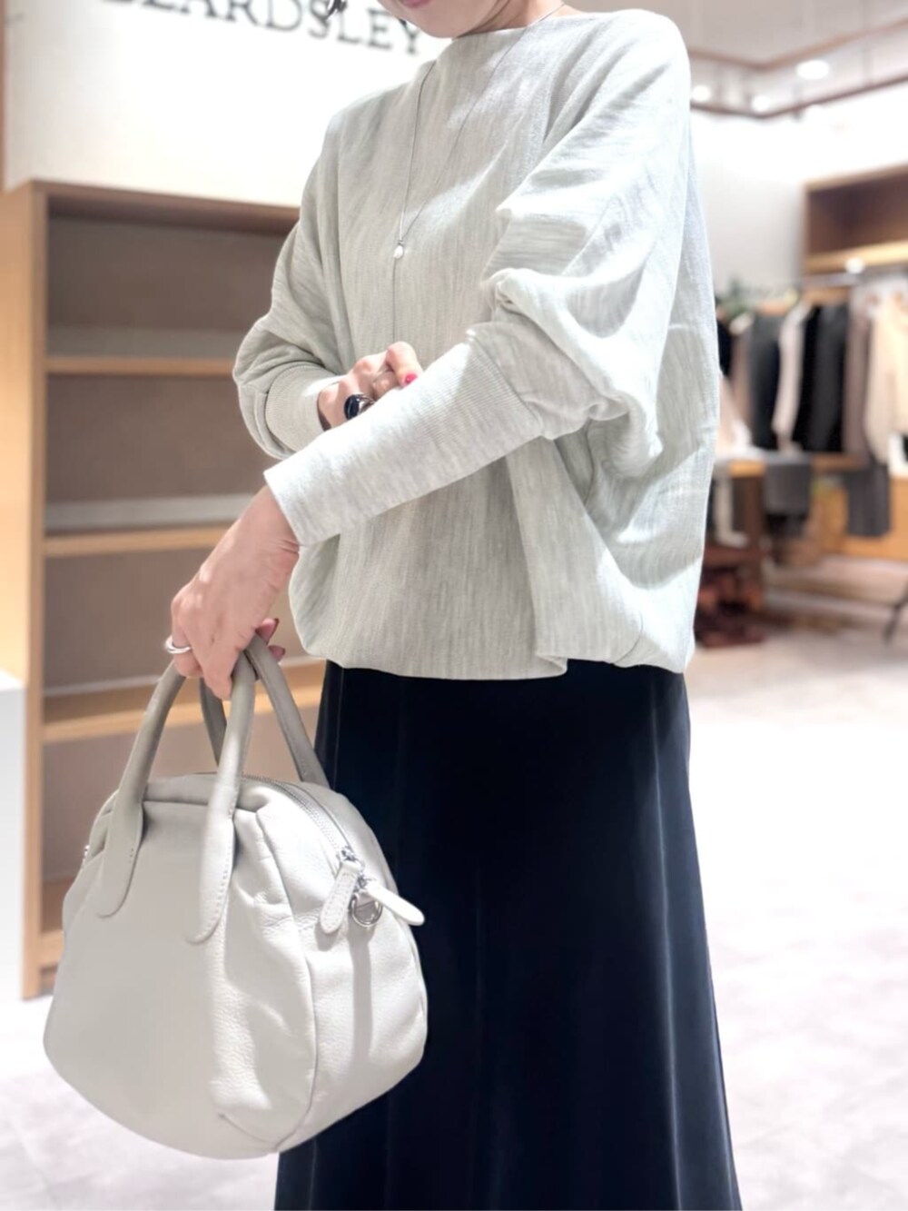 ブラック系のスカート、グレー系のボストンバッグ、グレー系のニット/セーターを着用したレディースの冬コーディネートの6枚目の写真