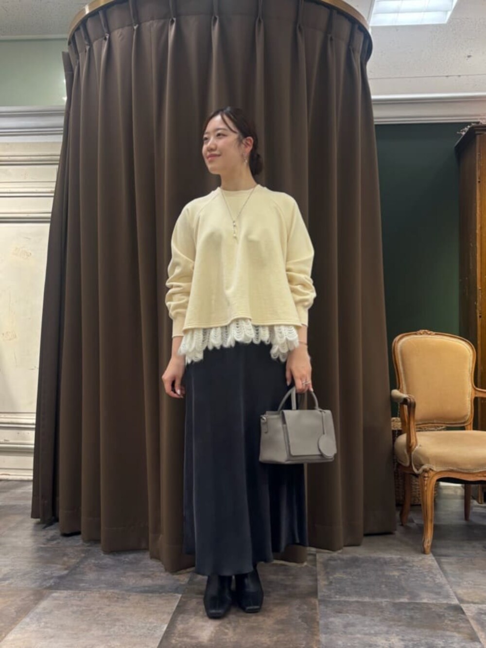 ブラック系のスカート、グレー系のハンドバッグ、ホワイト系のTシャツ/カットソーを着用したレディースの冬コーディネートの3枚目の写真