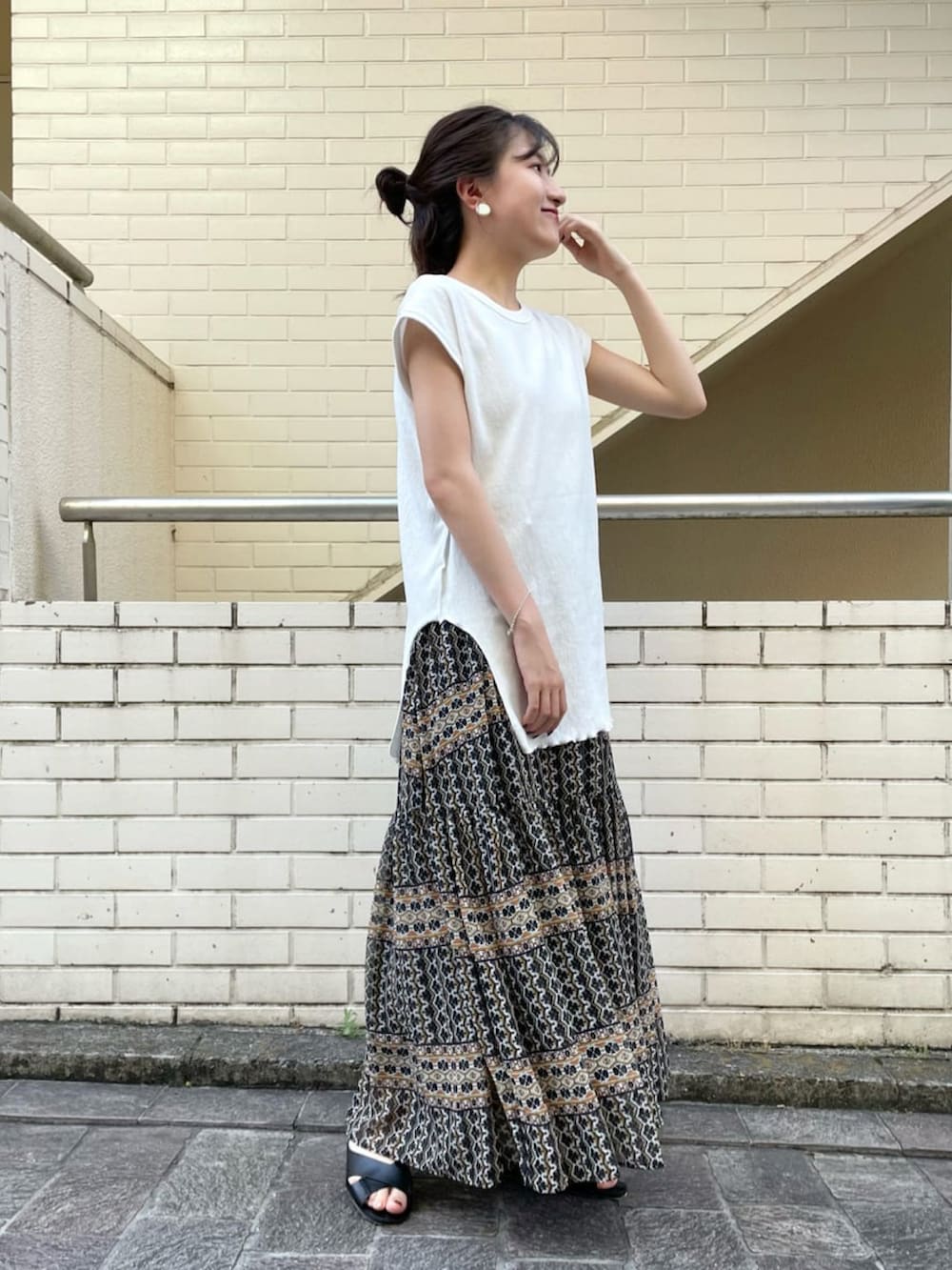 ホワイト系のTシャツ/カットソー、ブラック系のスカート、ブラック系のサンダルを着用したレディースの夏コーディネートの4枚目の写真